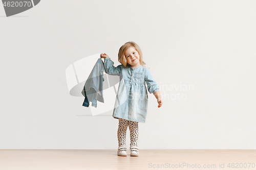 Image of Full length portrait of cute little kid in stylish jeans clothes looking at camera and smiling