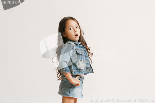 Image of The portrait of cute little kid in stylish jeans clothes looking at camera and smiling