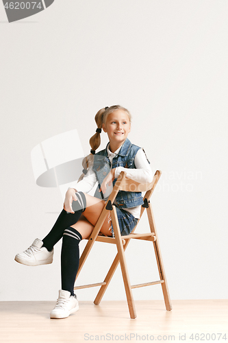 Image of Full length portrait of cute little teen in stylish jeans clothes looking at camera and smiling