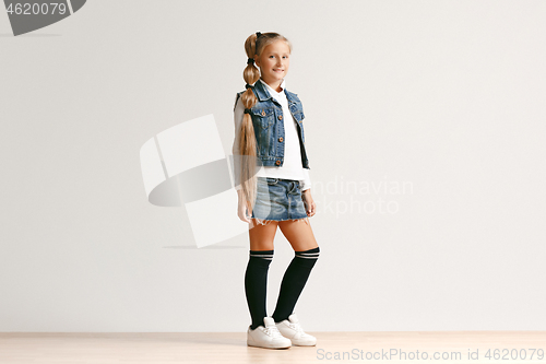 Image of Full length portrait of cute little teen in stylish jeans clothes looking at camera and smiling