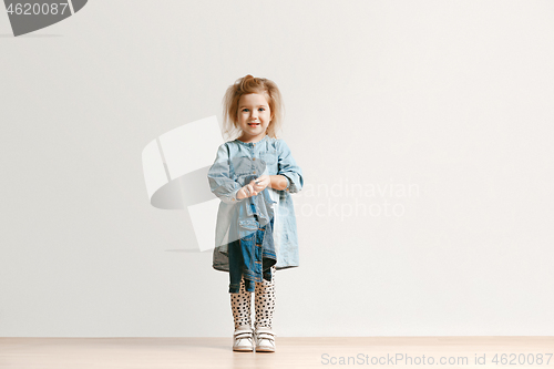 Image of Full length portrait of cute little kid in stylish jeans clothes looking at camera and smiling