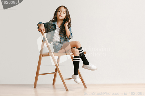 Image of Full length portrait of cute little kid in stylish jeans clothes looking at camera and smiling