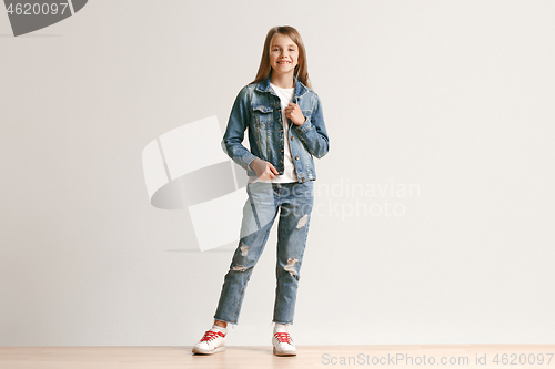 Image of Full length portrait of cute little teen in stylish jeans clothes looking at camera and smiling