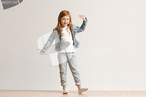 Image of Full length portrait of cute little kid in stylish jeans clothes looking at camera and smiling