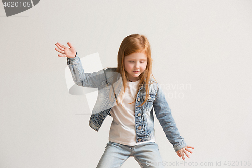 Image of portrait of cute little kid in stylish jeans clothes looking at camera and smiling