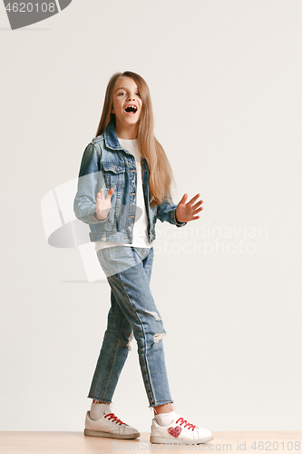 Image of Full length portrait of cute little teen in stylish jeans clothes looking at camera and smiling