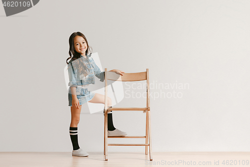 Image of Full length portrait of cute little kid in stylish jeans clothes looking at camera and smiling