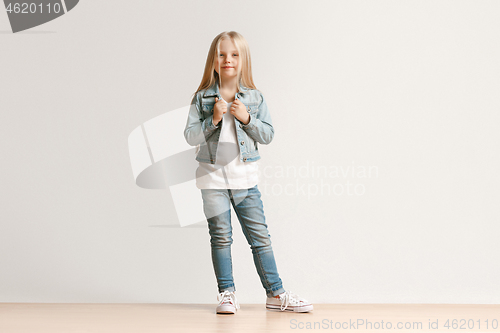 Image of Full length portrait of cute little kid in stylish jeans clothes looking at camera and smiling