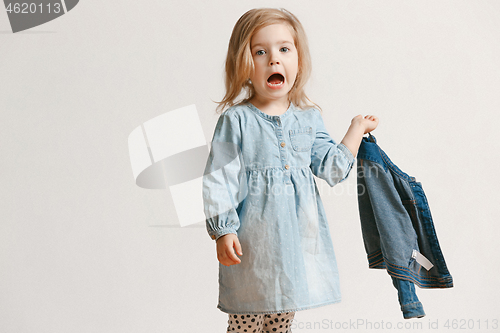 Image of Full length portrait of cute little kid in stylish jeans clothes looking at camera and smiling