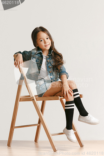 Image of Full length portrait of cute little kid in stylish jeans clothes looking at camera and smiling