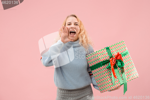 Image of Woman with big beautiful smile holding colorful gift box.