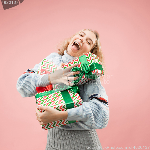 Image of Woman with big beautiful smile holding colorful gift boxes.