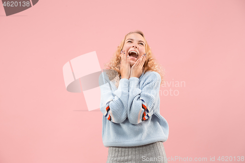 Image of The happy business woman standing and smiling against pink background.