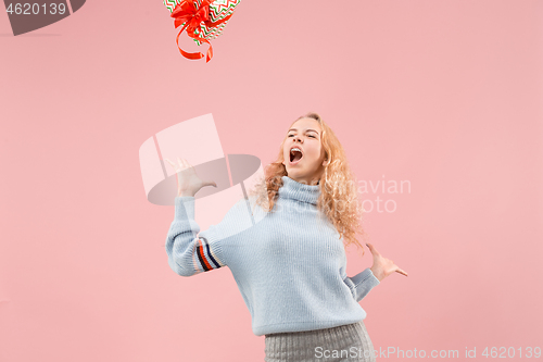 Image of Woman with big beautiful smile holding colorful gift box.