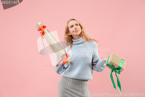 Image of Woman with big beautiful smile holding colorful gift boxes.