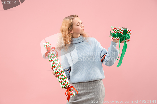 Image of Woman with big beautiful smile holding colorful gift boxes.