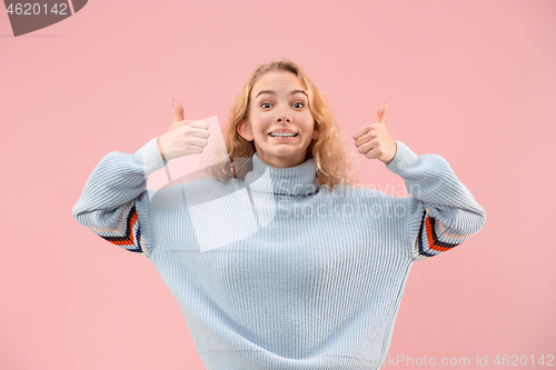 Image of The happy business woman standing and smiling against pink background.