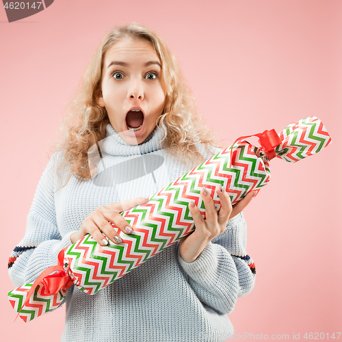 Image of Woman with big beautiful smile holding colorful gift box.