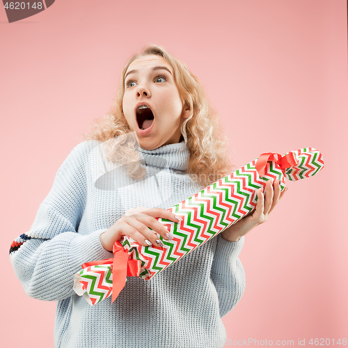 Image of Woman with big beautiful smile holding colorful gift box.