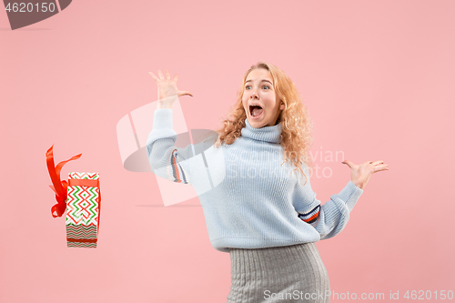 Image of Woman with big beautiful smile holding colorful gift box.