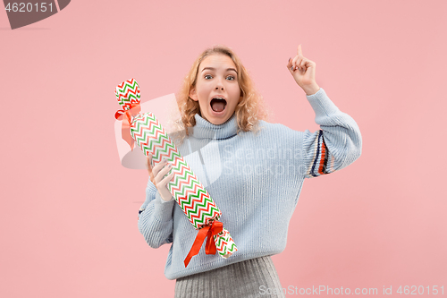 Image of Woman with big beautiful smile holding colorful gift box.