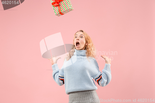 Image of Woman with big beautiful smile holding colorful gift box.