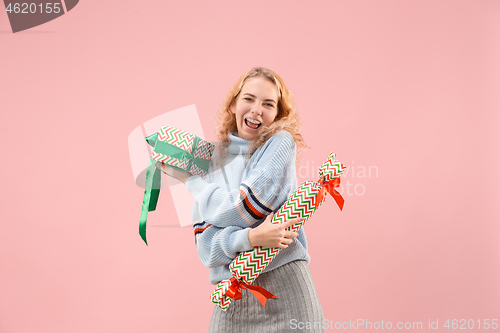 Image of Woman with big beautiful smile holding colorful gift boxes.