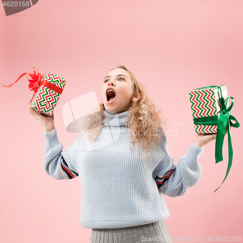 Image of Woman with big beautiful smile holding colorful gift boxes.