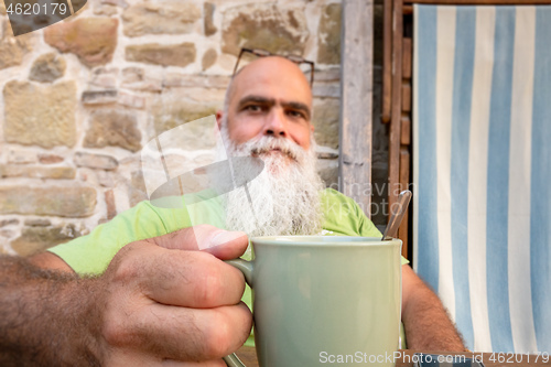 Image of bearded man hands on coffee mug