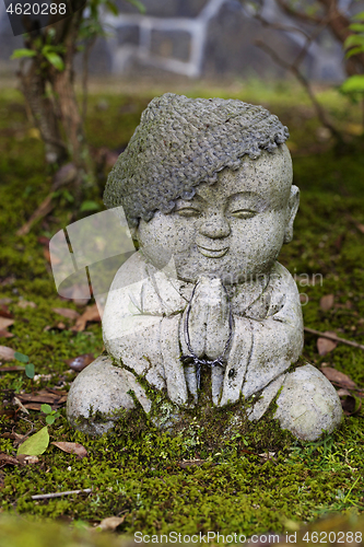 Image of Jizo stone statue wearing knitted and cloth hats.