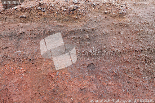 Image of A cut of soil with rocks and red soil