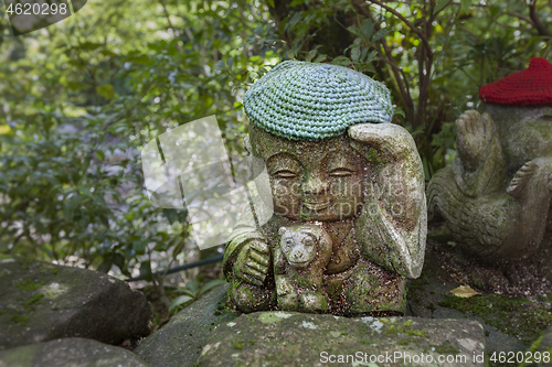 Image of Monkey - symbol of japanese horoscope. Jizo stone statue wearing knitted and cloth hats.