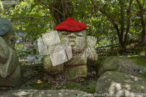 Image of Rooster - symbol of japanese horoscope. Jizo stone statue wearing knitted and cloth hats.