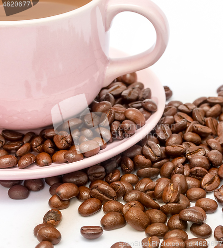 Image of Coffee beans next to a cup of freshly brewed 
