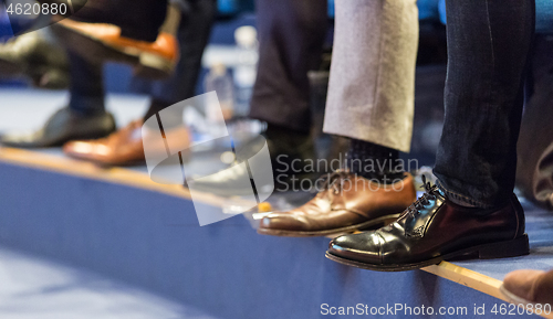 Image of Detail of row of men\'s formal corporate business shoes. Business people sitting at seminar.