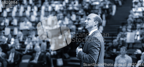 Image of Public speaker giving talk at Business Event.