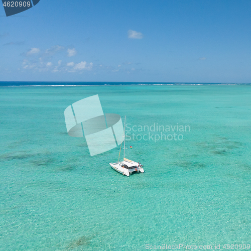 Image of Catamaran sailing boat in turquoise sea lagoon on tropial Mauritius island. Aerial, drone view.