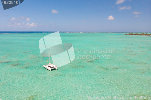 Image of Catamaran sailing boat in turquoise sea lagoon on tropial Mauritius island. Aerial, drone view.