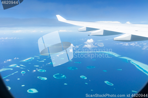 Image of Top view of Maldive islands from airplane window with airplane\'s wing