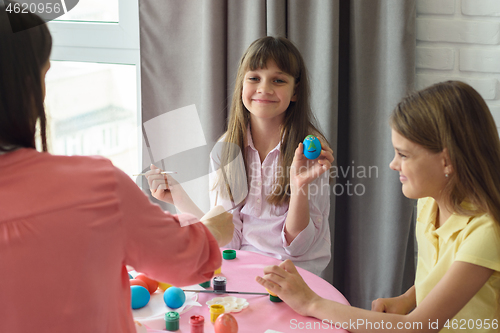 Image of Happy girl shows a painted easter egg