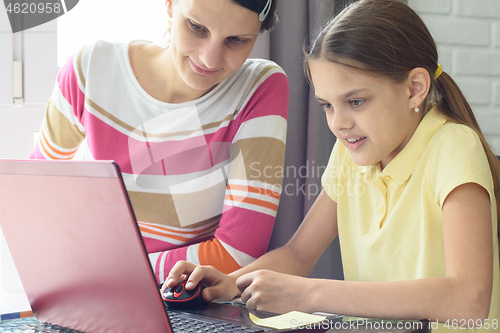 Image of Girl learns to work on the Internet, mom helps her