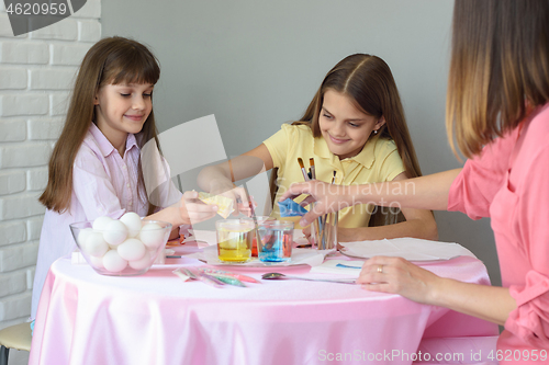 Image of Mom with daughters fall asleep dye for coloring eggs in glasses with water