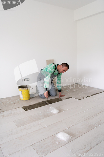 Image of worker installing the ceramic wood effect tiles on the floor