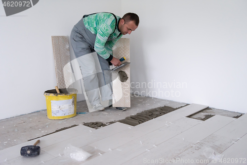 Image of worker installing the ceramic wood effect tiles on the floor