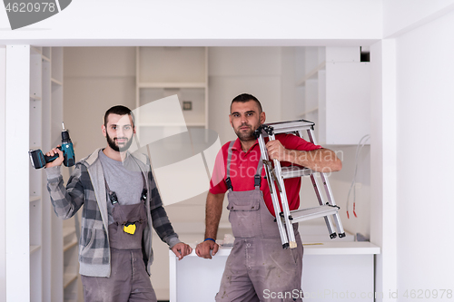 Image of young workers installing a new kitchen