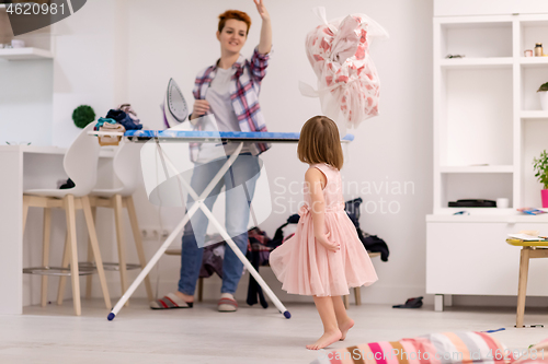 Image of mother and little daughter spending time together at home