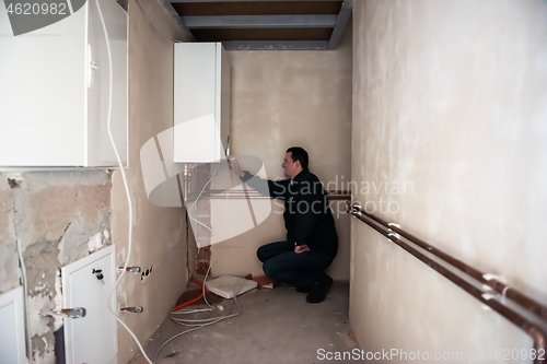 Image of engineer checking technical data of heating system