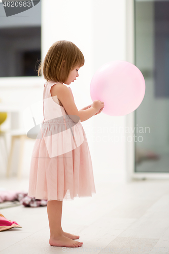 Image of cute little girl playing with balloons