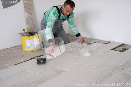 Image of worker installing the ceramic wood effect tiles on the floor