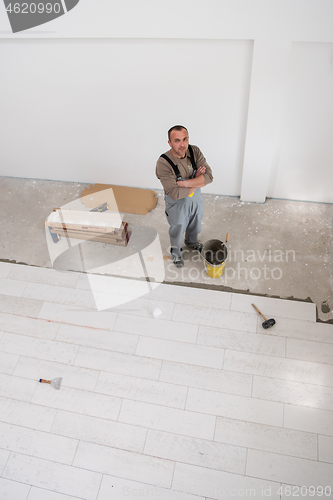 Image of worker installing the ceramic wood effect tiles on the floor